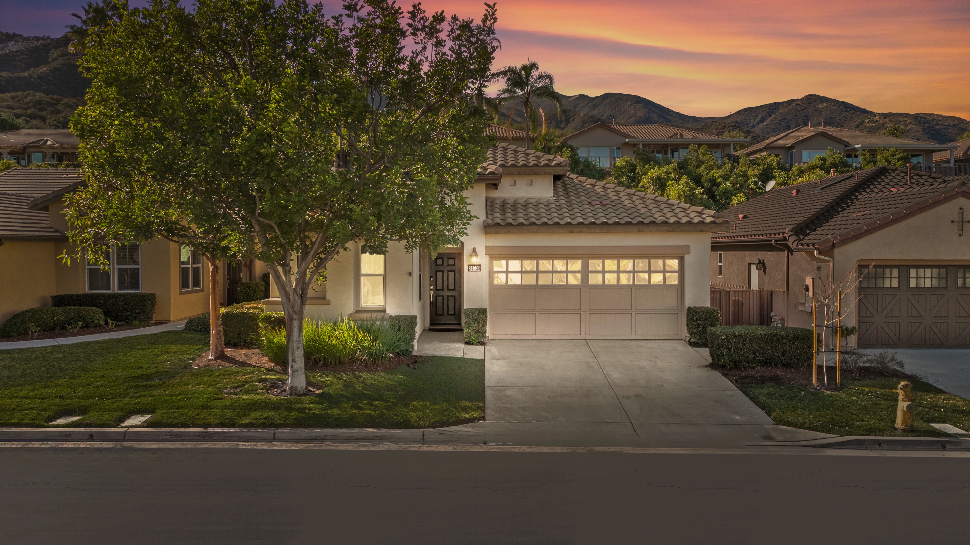 Twilight exterior with mountain backdrop and warm lighting